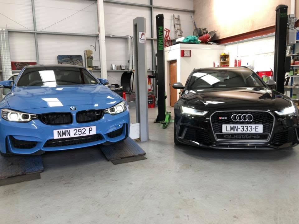 A BMW M car and an Audi RS6 up on the ramps inside Bailey's Garage