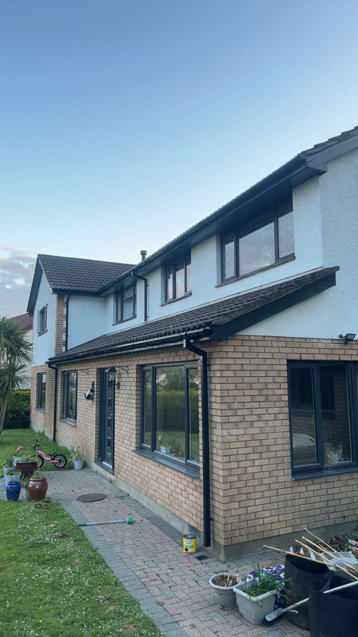 Renovated house exterior with render, brick and black-framed windows