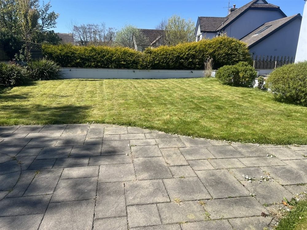 Block-paved patio beside a freshly mown lawn