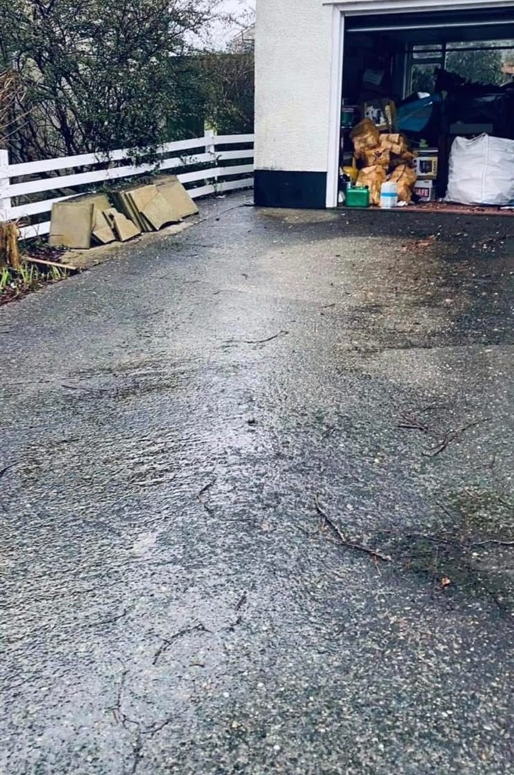 The same driveway before jet washing, dark with grime