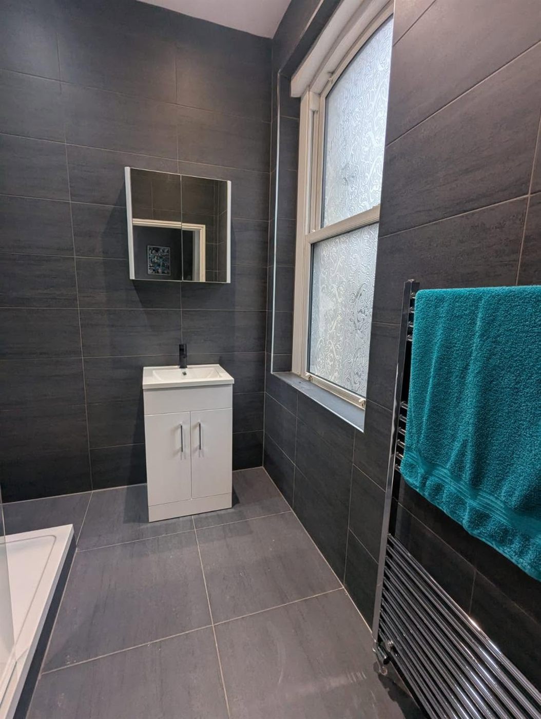 Fully tiled grey bathroom