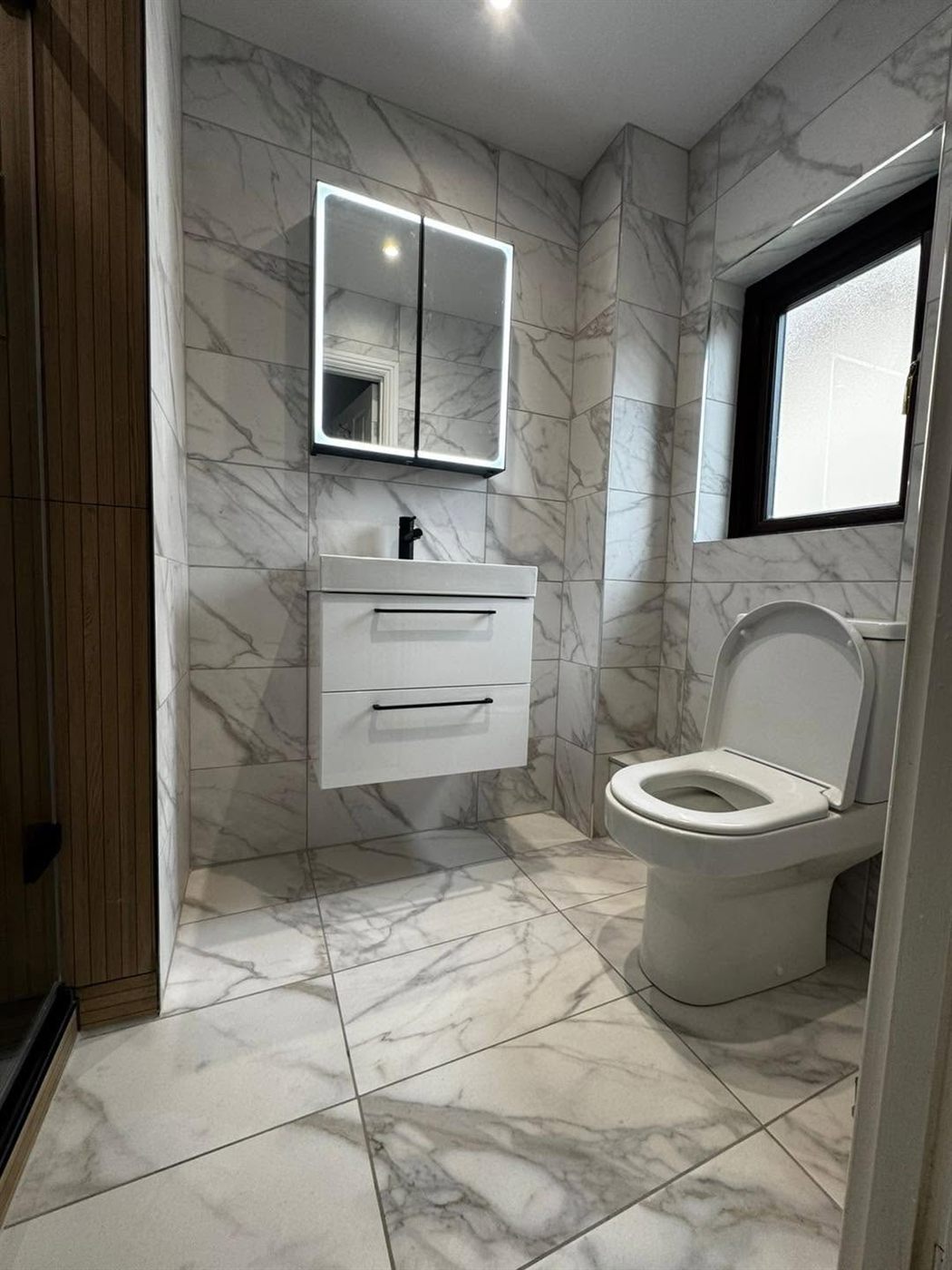 Marble-tiled bathroom with floating vanity