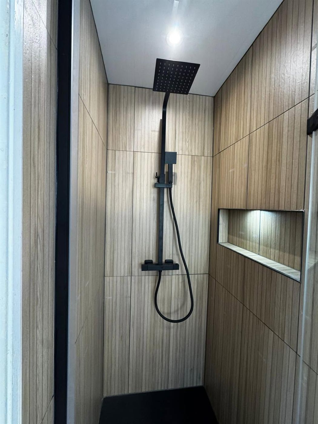 Wood-effect wet room with black rainfall shower